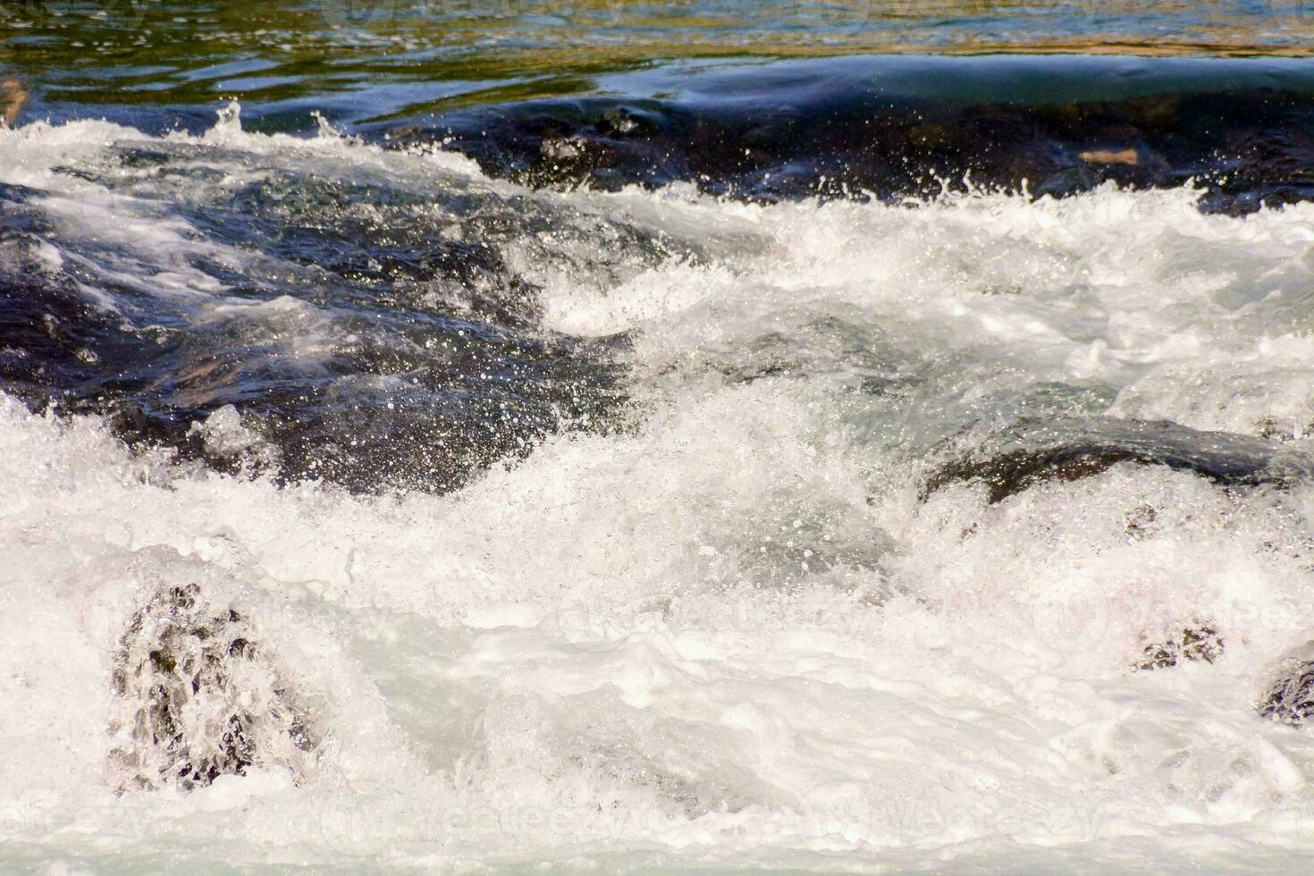 ein schließen oben von ein Fluss mit Wasser eilen Über Felsen foto
