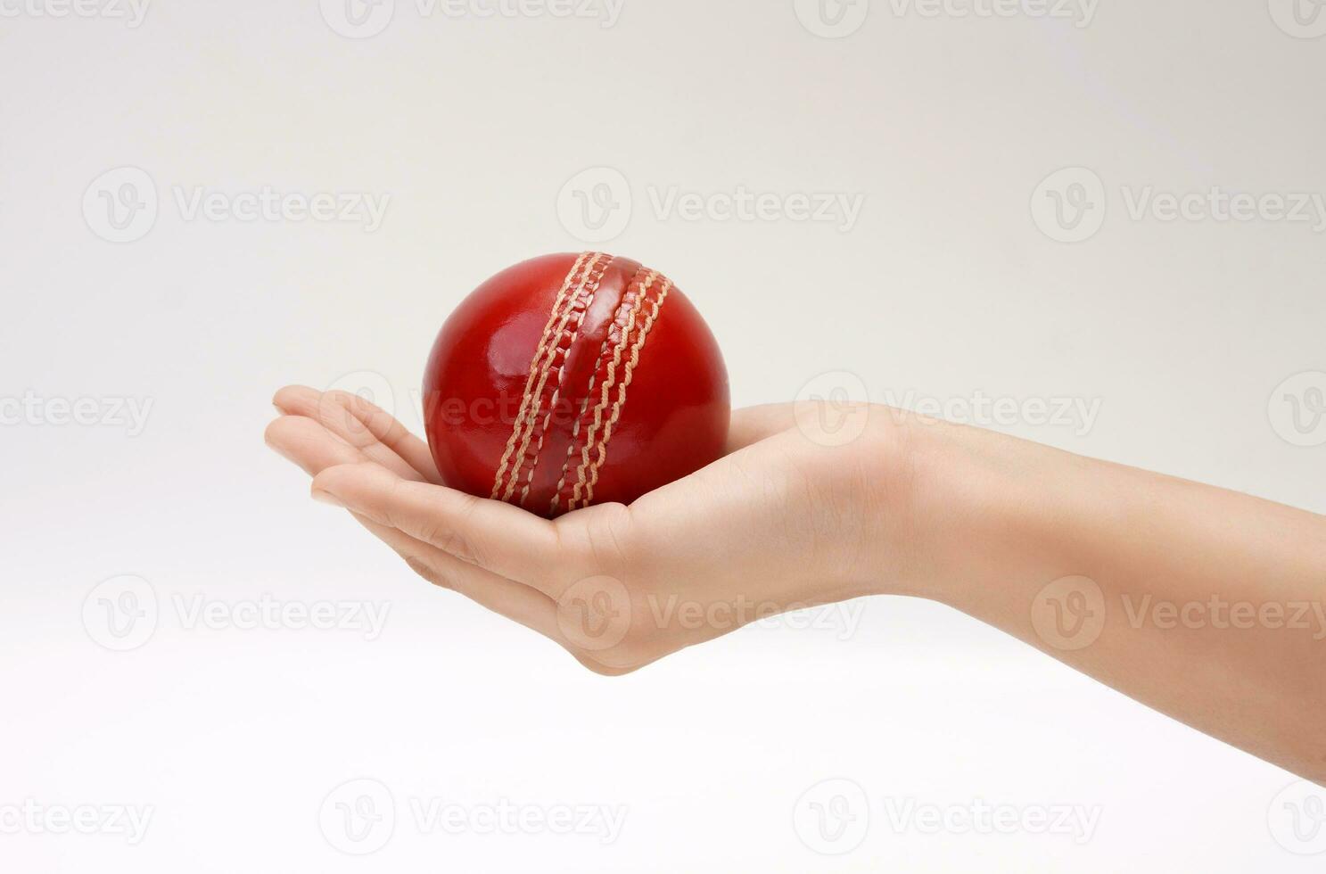 glänzend rot Prüfung Spiel Leder Stich Kricket Ball im Frauen Hand Nahansicht Bild Weiß Hintergrund foto