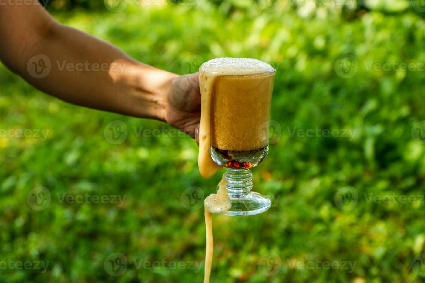 weiblich Hand hält ein Glas mit Weiß Kwas, Sanft Getränke foto