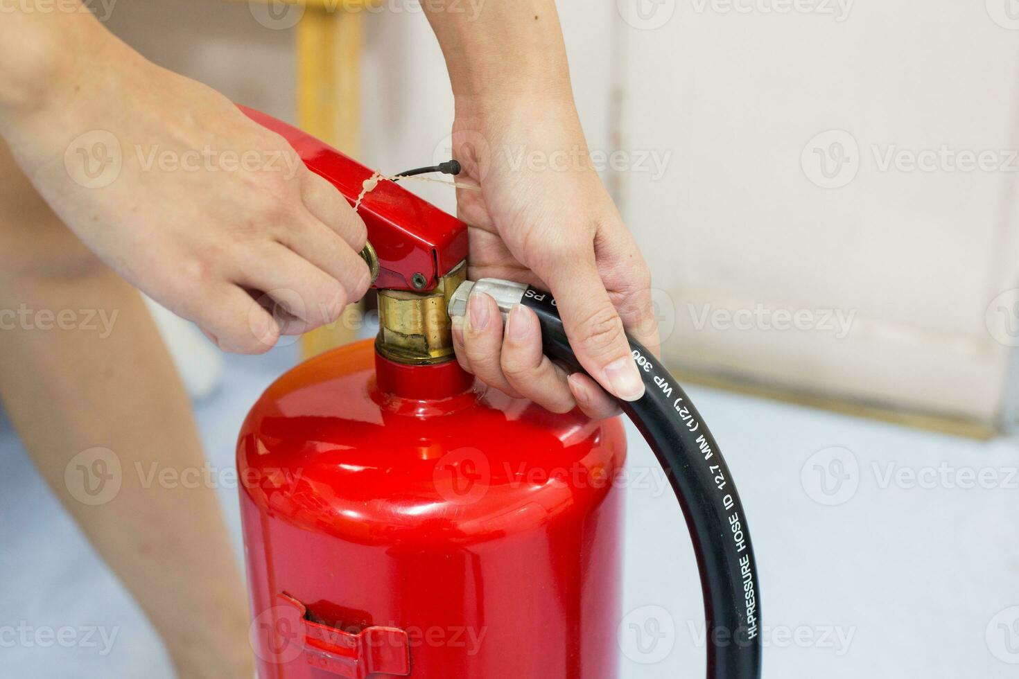 schließen- oben Feuer Feuerlöscher und ziehen Stift auf rot Panzer. foto