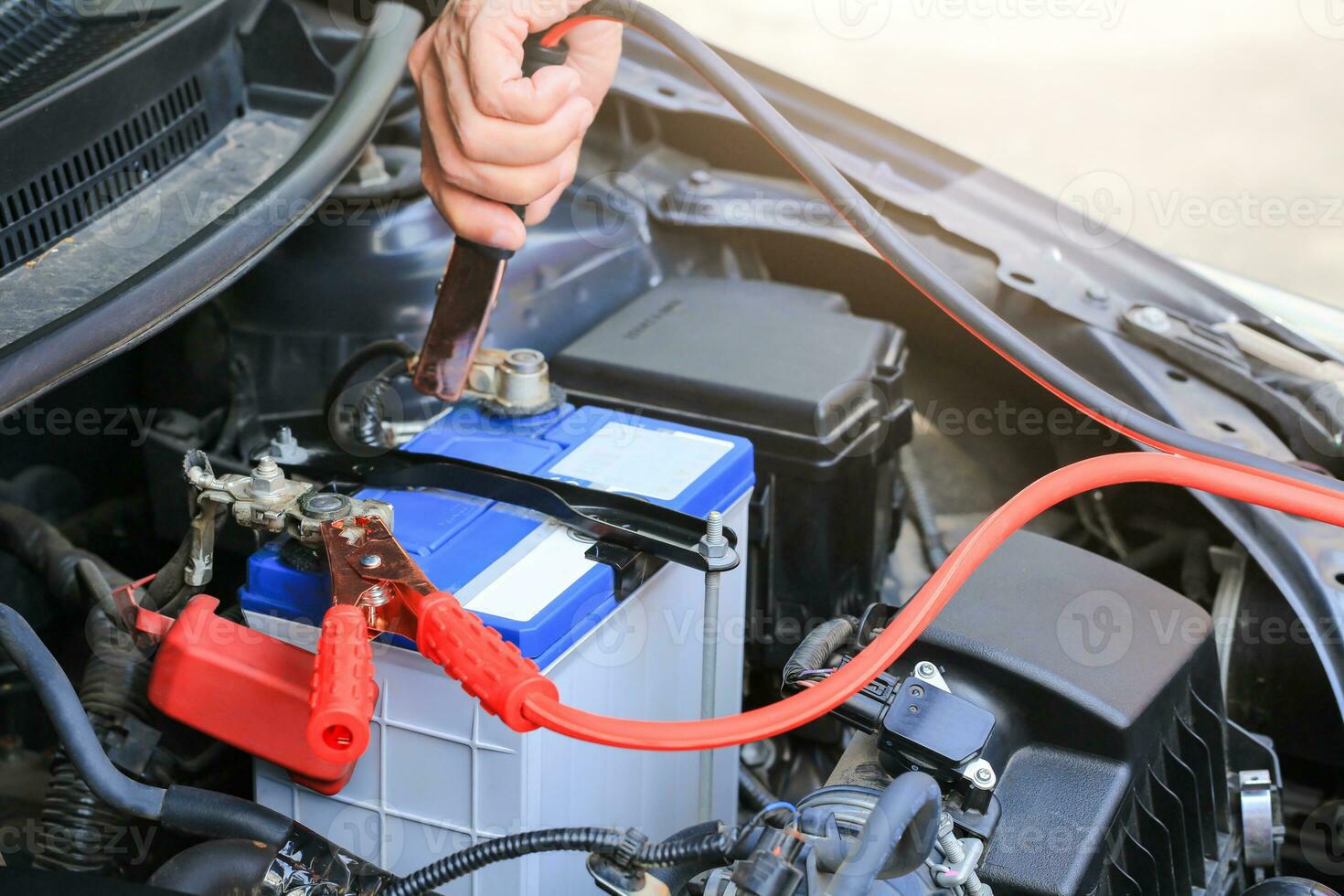 Auto Mechaniker Verwendet Batterie Jumper Kabel aufladen ein tot Batterie. foto