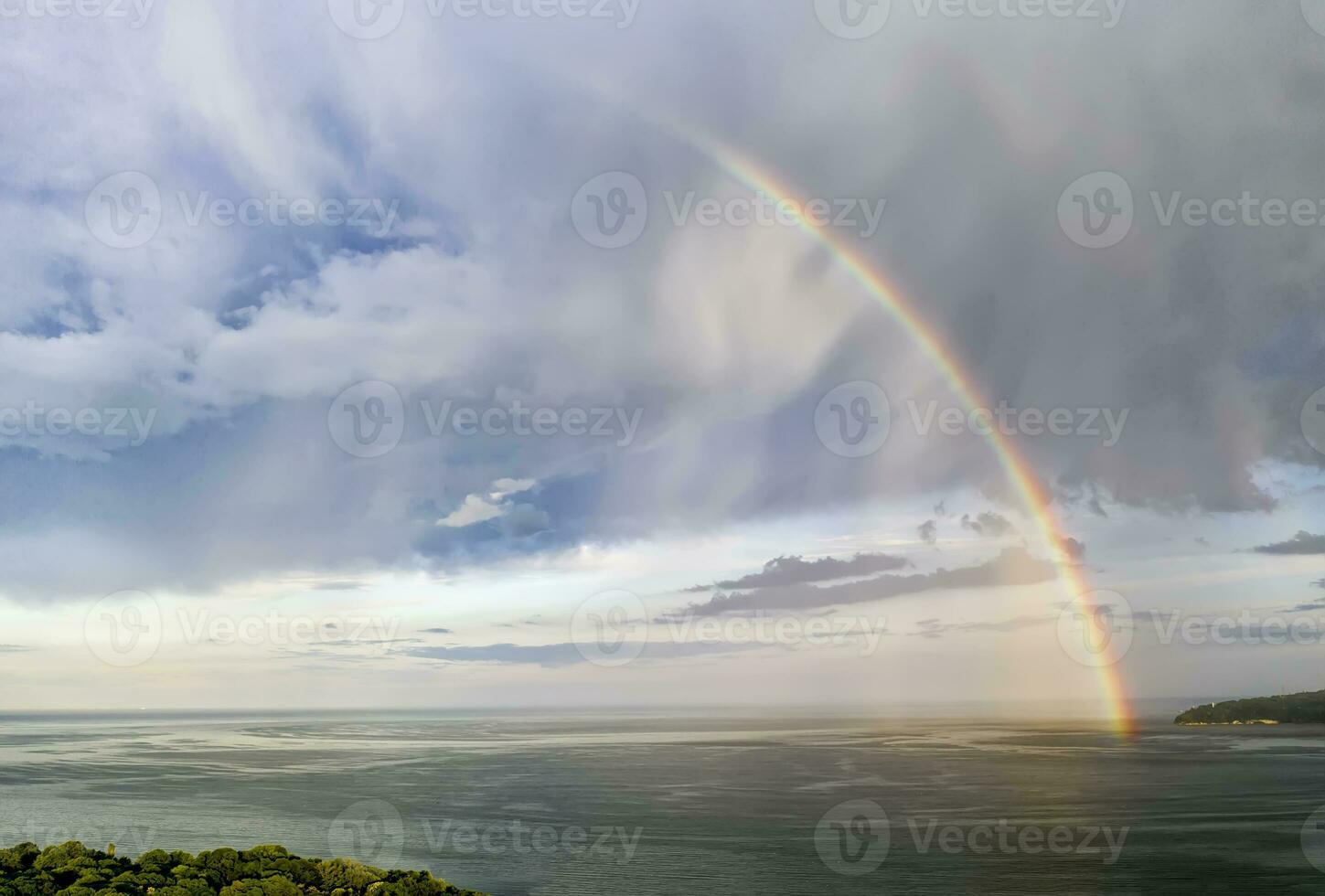 atemberaubend groß Regenbogen nach das Regen Über das Meer foto