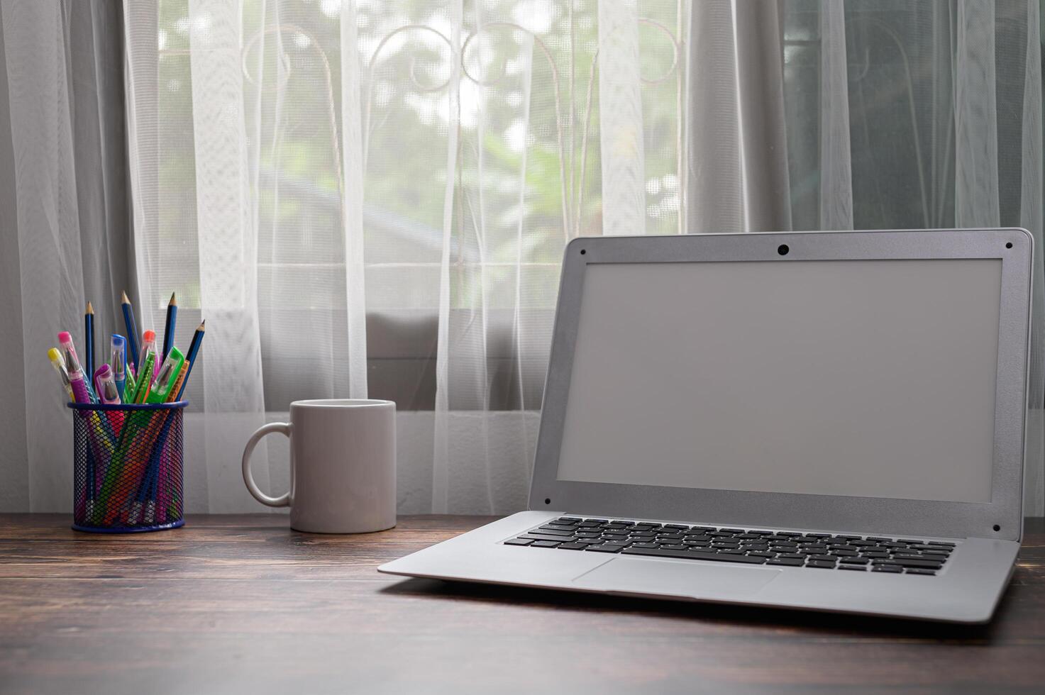 Computer, Notebooks und Wassergläser stehen am Schreibtisch. foto