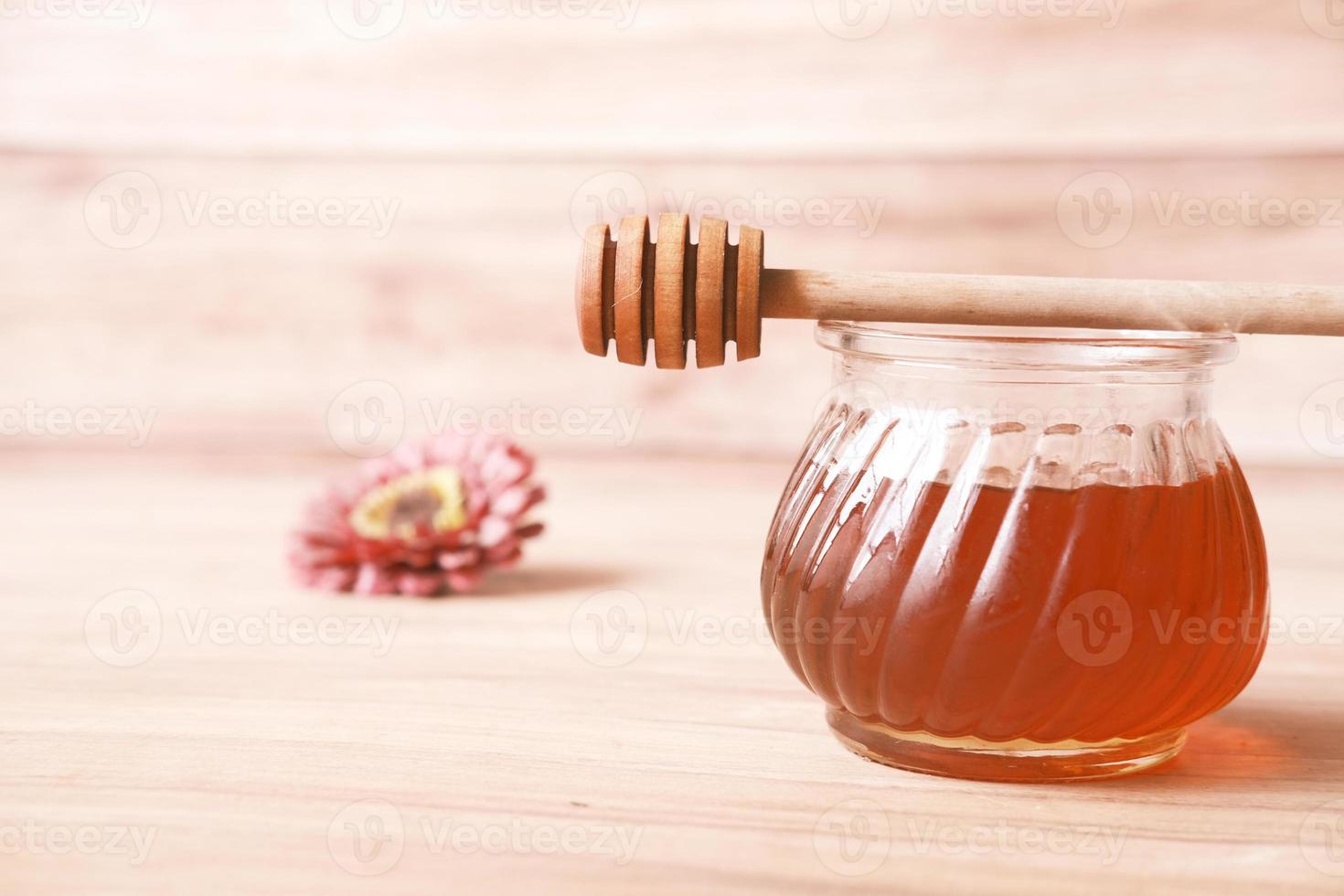 Nahaufnahme von frischem Honig mit Löffel auf dem Tisch foto