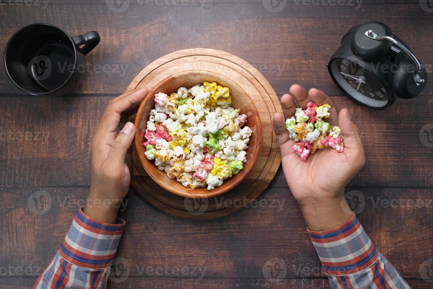 junger Mann, der Popcorn-Draufsicht isst foto