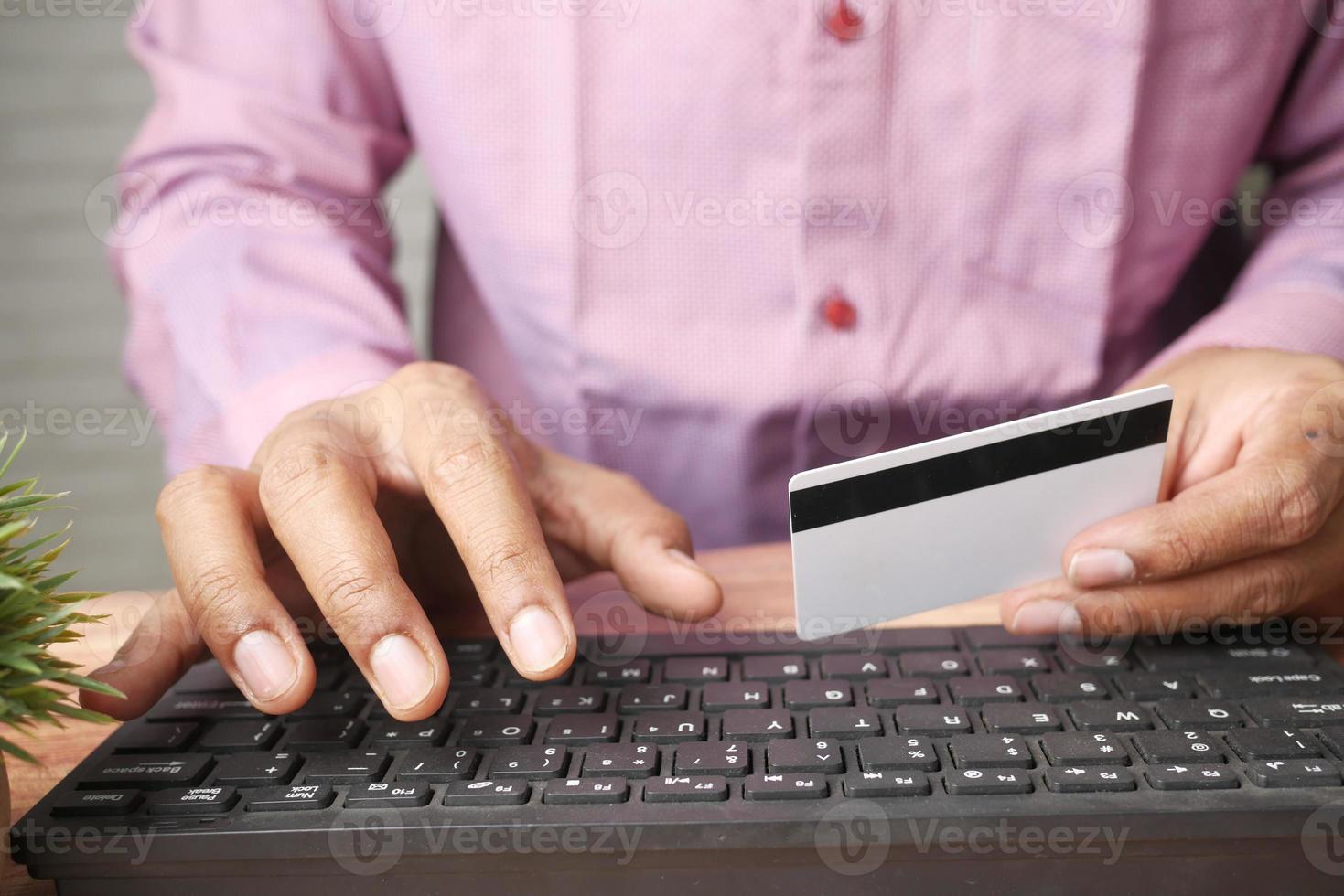 junger Mann, der Online-Shop mit Kreditkartendetails betritt foto