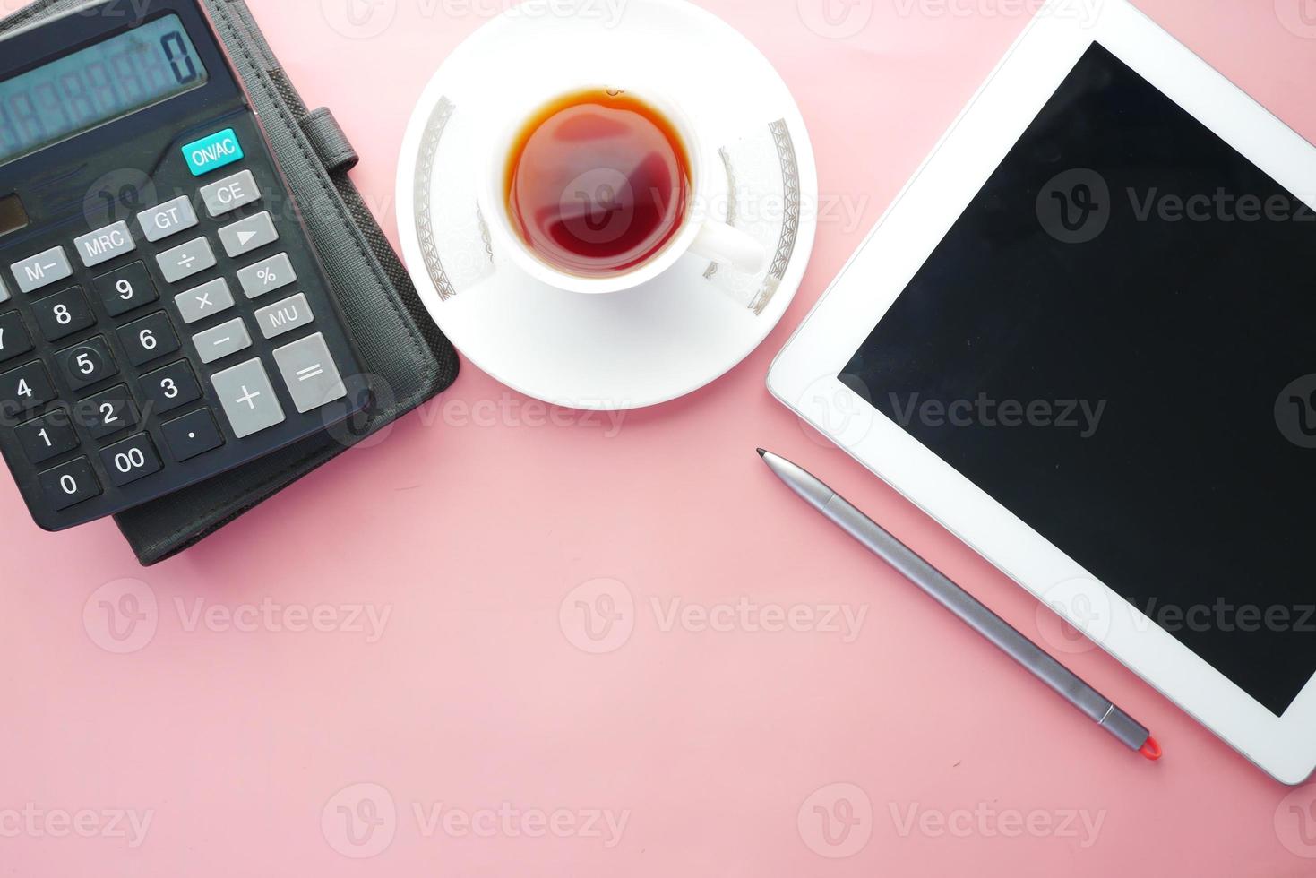 flache Komposition aus digitalem Tablet und Büromaterial auf rosa Hintergrund foto