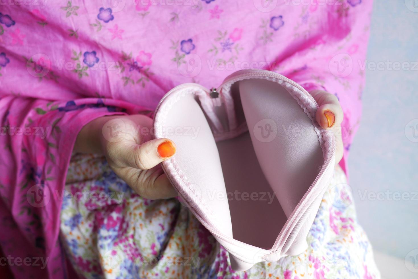 Frauen öffnen eine leere Brieftasche auf rosa Hintergrund foto