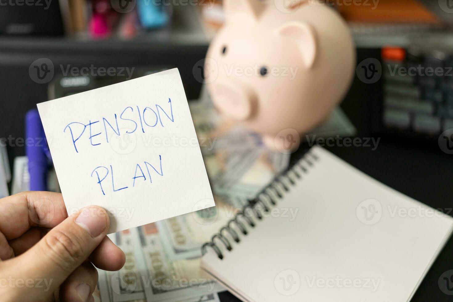 Papier Hinweis mit Text die Pension planen mit Schreibwaren auf Schreibtisch. die Pension planen. Pensionierung Konzept. die Pension Berechnung Konzept. Kopieren Raum zum Text. Schweinchen Bank. foto