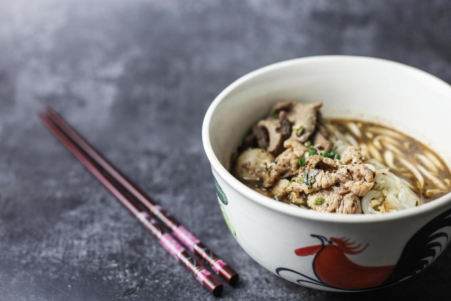 Thai Boat Noodles ist Thailands berühmteste Nudelsuppe, Thai Boat Noodles Soup oder Guay Tiew Reua, Reisnudeln verdicken Suppe mit geschmortem Schweinefleisch und Schweinebällchen, geschmortem Schweinefleisch und Leberschweinefleisch, foto