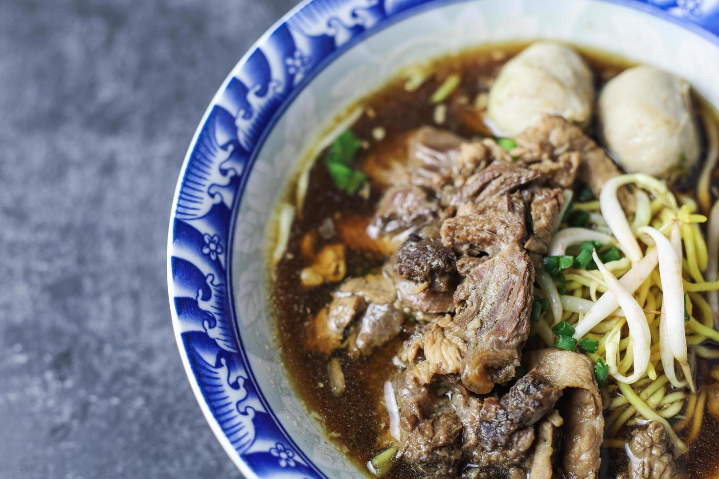 Thai Boat Noodles ist Thailands berühmteste Nudelsuppe, Thai Boat Noodles Soup oder Guay Tiew Reua, Reisnudeln verdicken Suppe mit geschmortem Schweinefleisch und Schweinebällchen, geschmortem Schweinefleisch und Leberschweinefleisch, foto