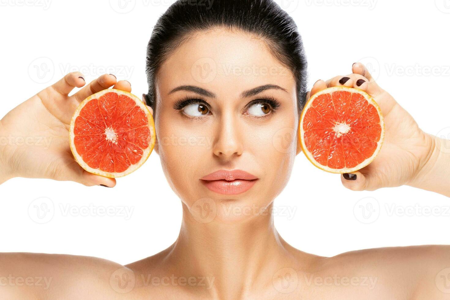 gesund Essen Konzept. schön jung Frau halten Stück von Grapefruit schließen zu Gesicht, isoliert Über Weiß Hintergrund foto