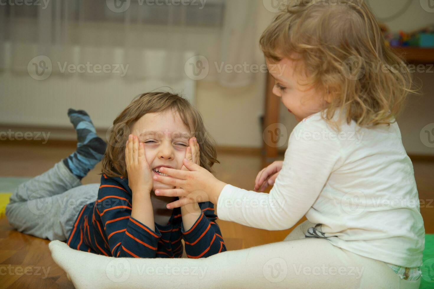 zwei Kinder spielen auf das Fußboden foto