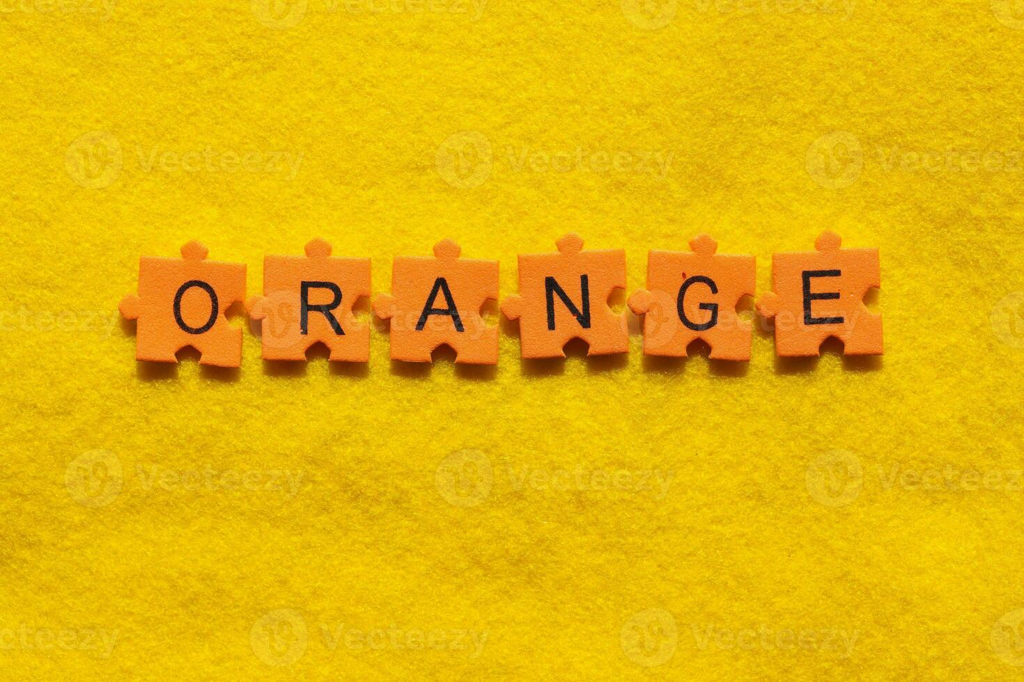 Orange Wort auf Gelb Hintergrund mit Puzzle Stücke foto