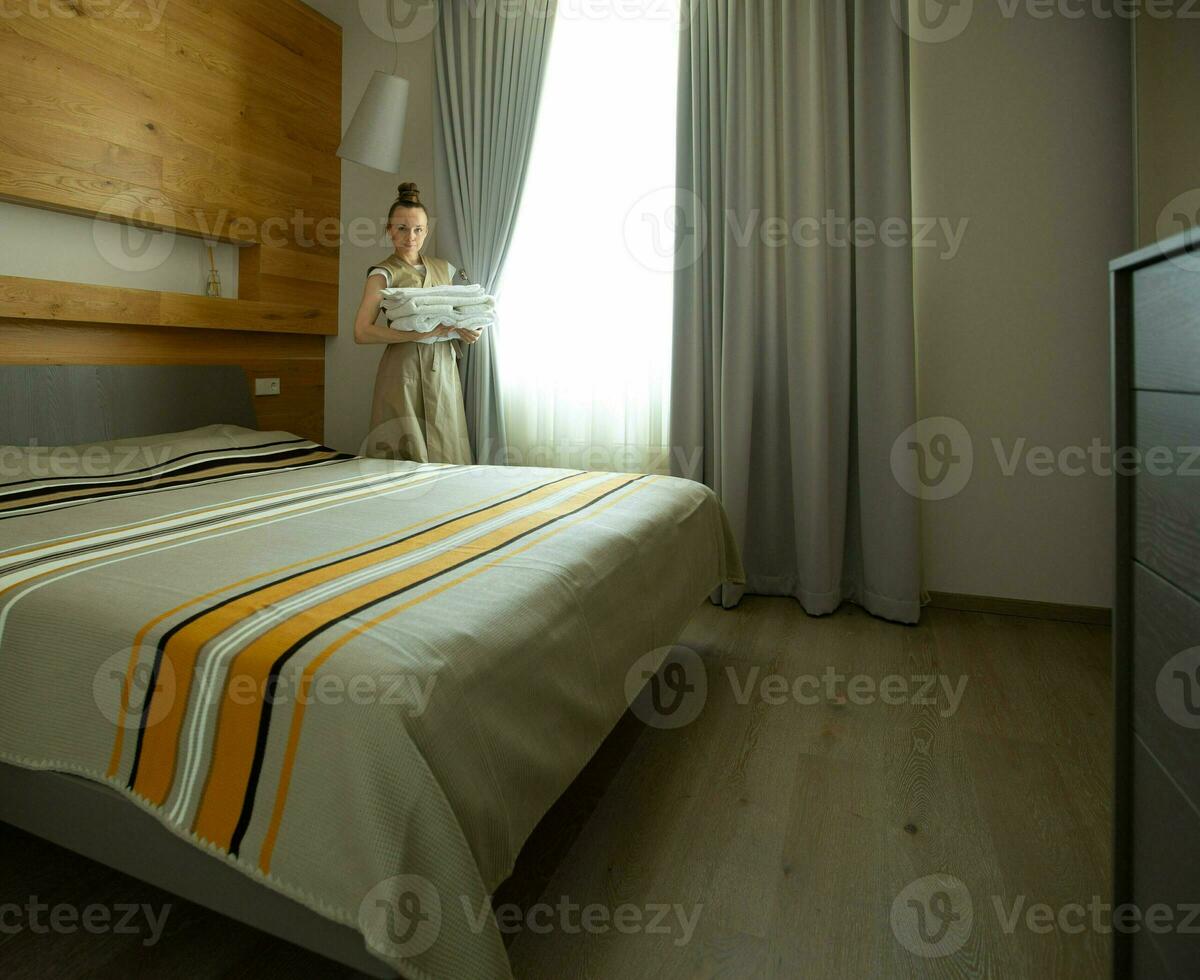 ein Frau ist Putten ein Decke auf ein Bett foto