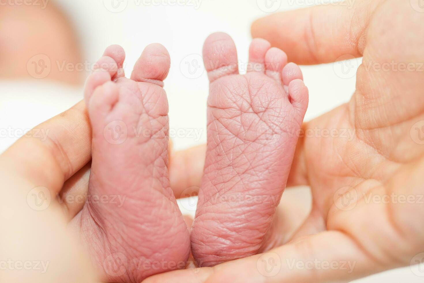 Nahansicht von ein Neugeborene Füße und ihr Vater Hände beim Krankenhaus auf das Tag von ihr Geburt foto