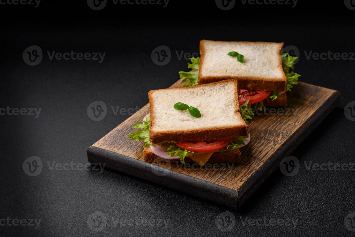 köstlich Sandwich mit Toast, Schinken, Tomaten, Käse und Grüner Salat foto