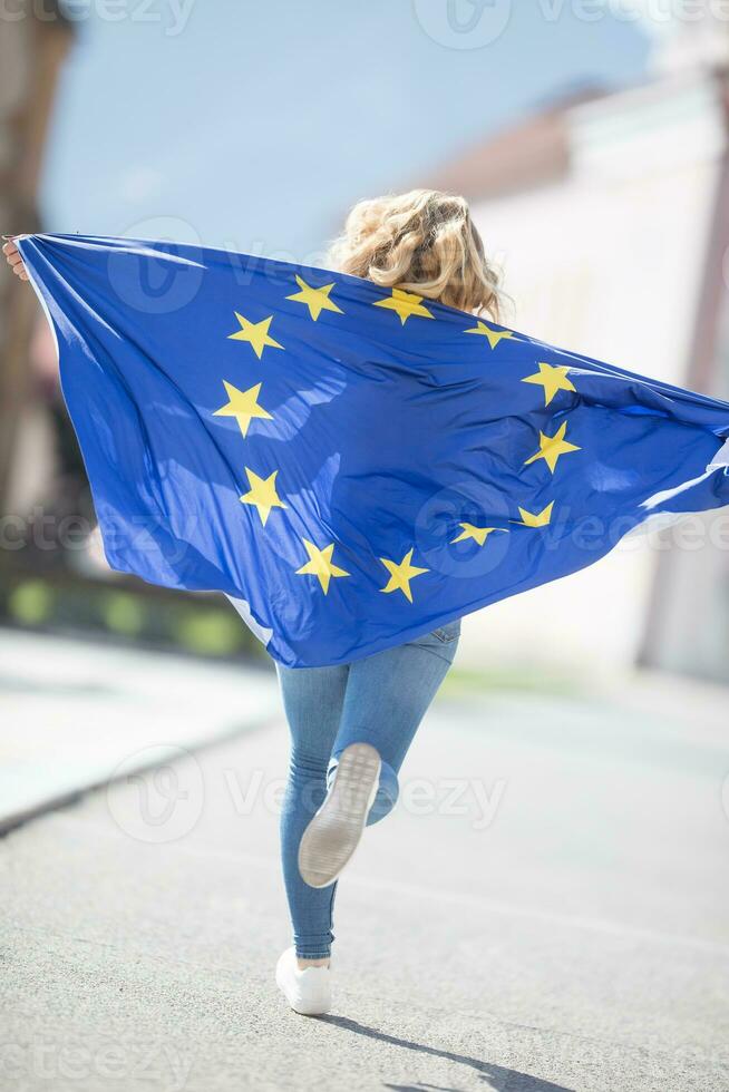 attraktiv glücklich jung Mädchen mit das Flagge von das europäisch Union foto