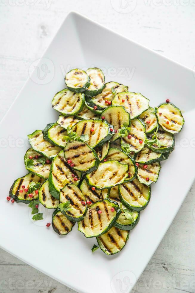 Zucchini. gegrillt Zucchini mit rot würzen auf Weiß Teller foto