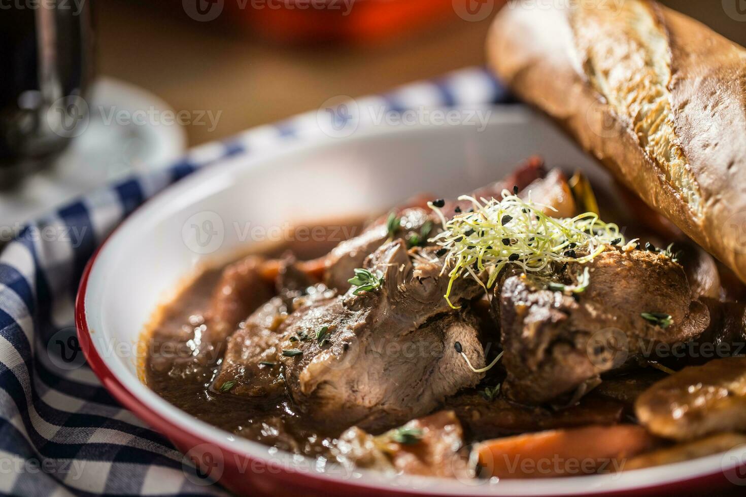 braten wild Eber mit Karotte Pilze, Stangenbrot und Entwurf Bier foto