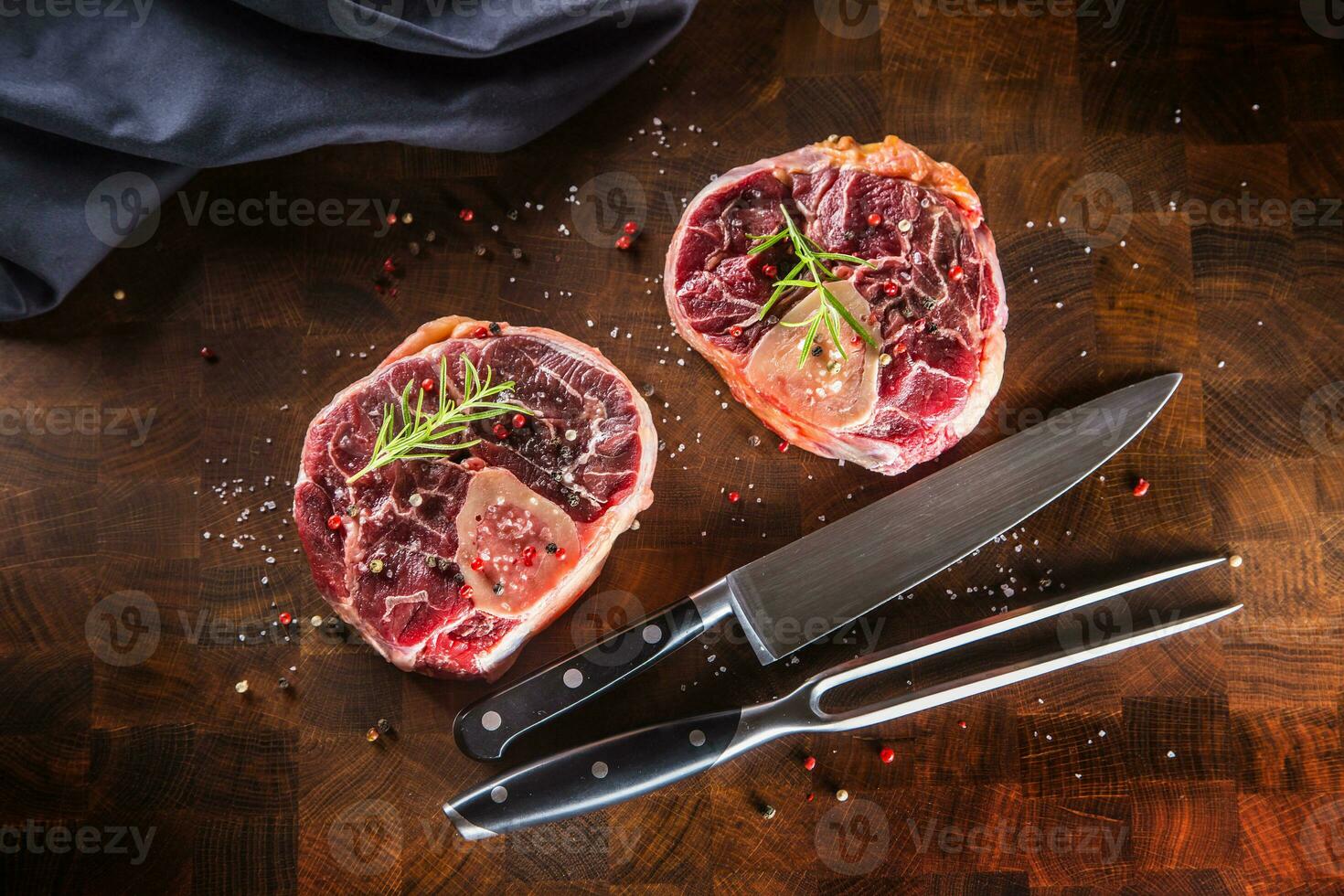 zwei roh Stücke Rindfleisch Schaft auf hölzern Metzger Tafel mit Gabel und Messer. foto