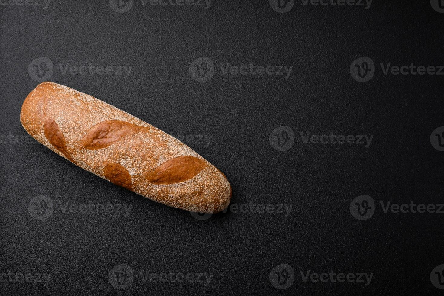 Französisch Stangenbrot Brot auf ein dunkel texturiert Beton Hintergrund foto