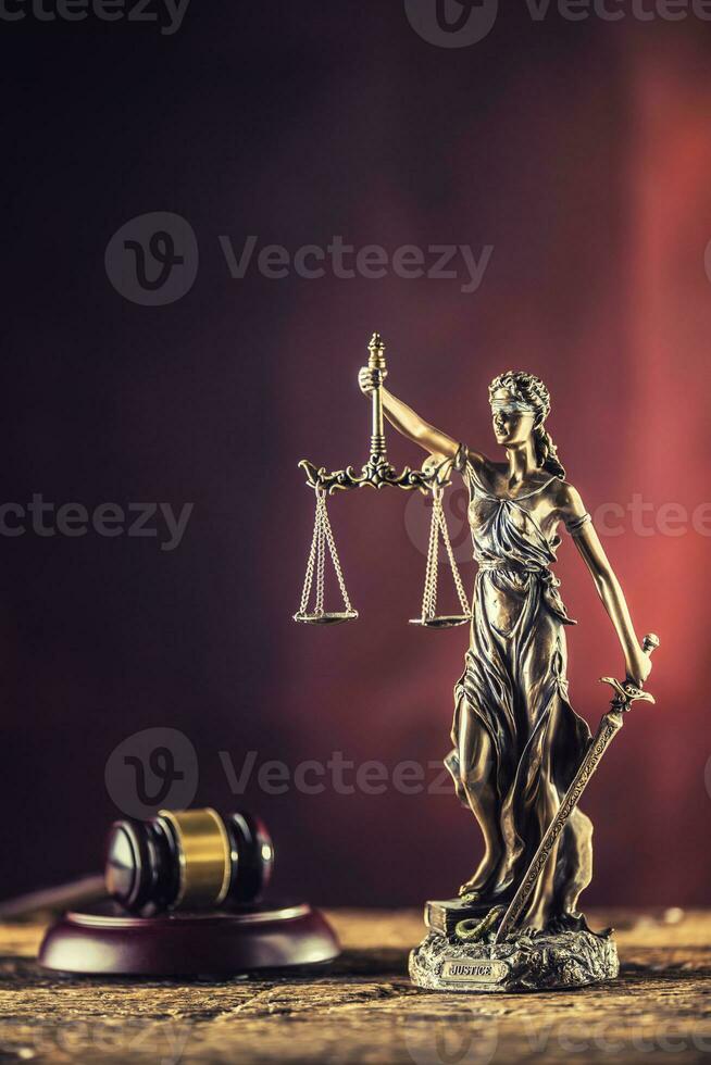 Dame Justicia halten Schwert und Rahmen Bronze- Figur mit Richter Hammer auf hölzern Tabelle foto