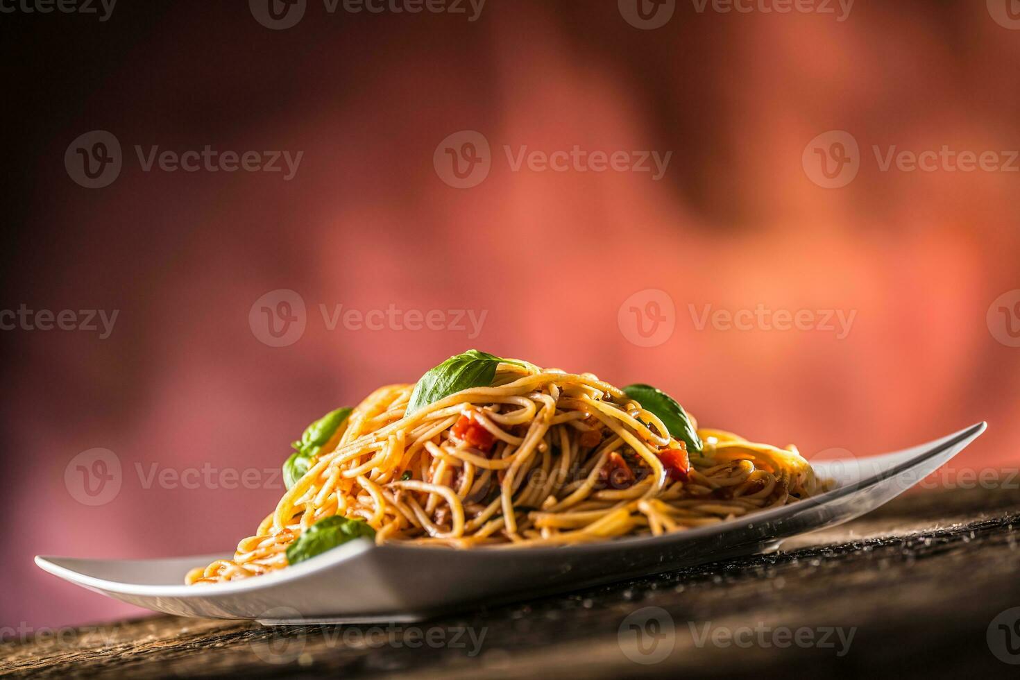 Italienisch Pasta Spaghetti mit Tomate Soße Basilikum und Parmesan Käse im Weiß Teller foto