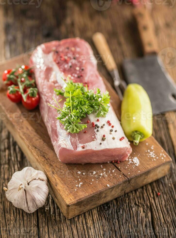 Schweinefleisch Lende Filet Petersilie Kraut Tomaten Pfeffer Knoblauch Salz- und Gewürze auf hölzern Küche Tafel. foto