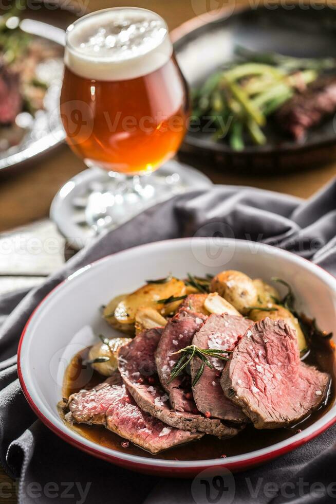 geschnitten Rindfleisch Filet geröstet Steak Kartoffeln Rosmarin und Entwurf Bier foto