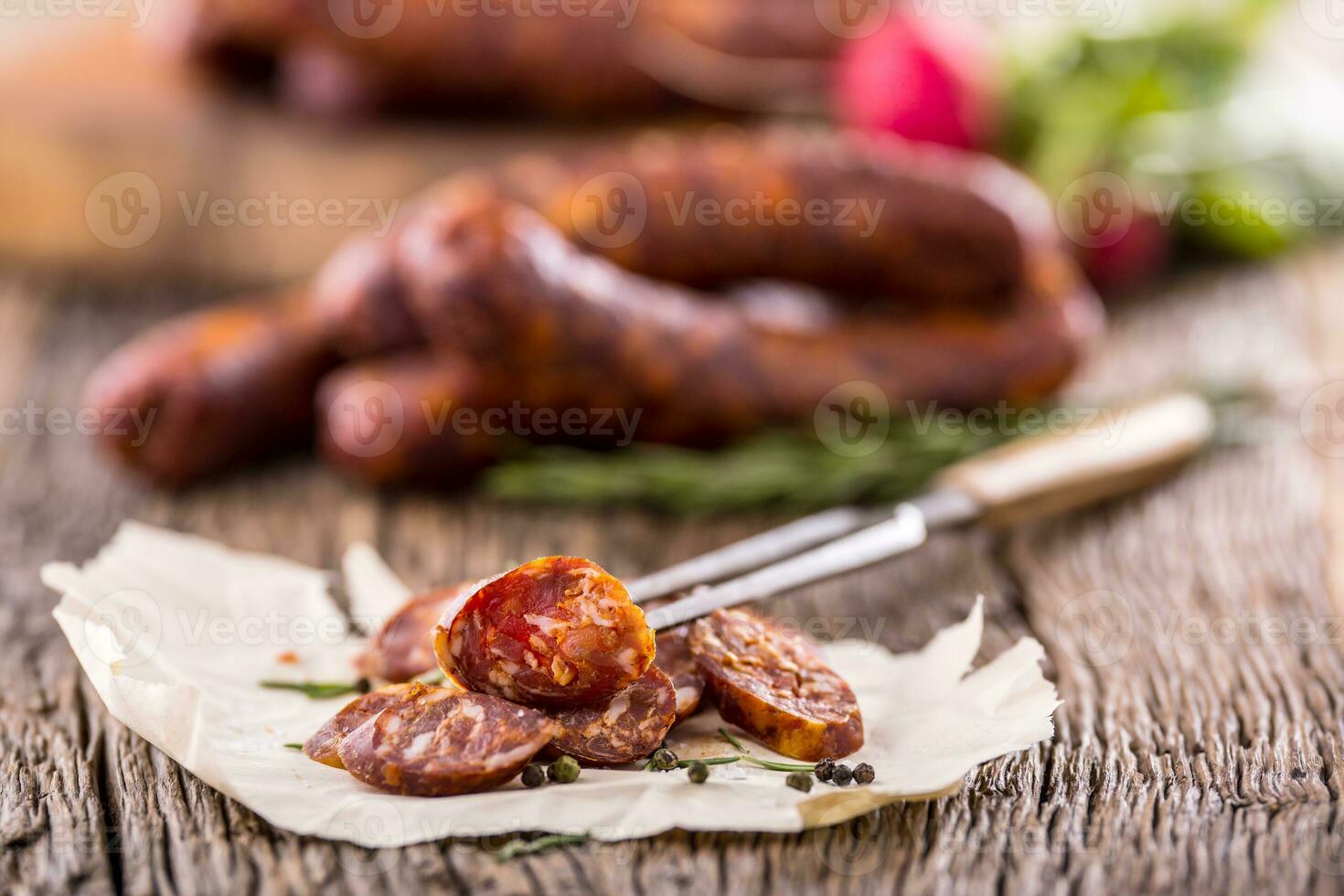 Würste. geräuchert Würste. Chorizo Würste mit Gemüse Rosmarin Gewürze und Küche Utensil. foto