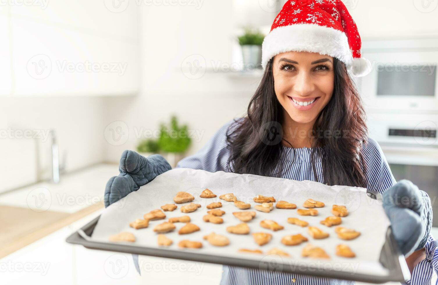 schön Bäcker im Weihnachten Hut zeigt an ihr arbeiten. lecker Lebkuchen auf ein Backen Papier foto