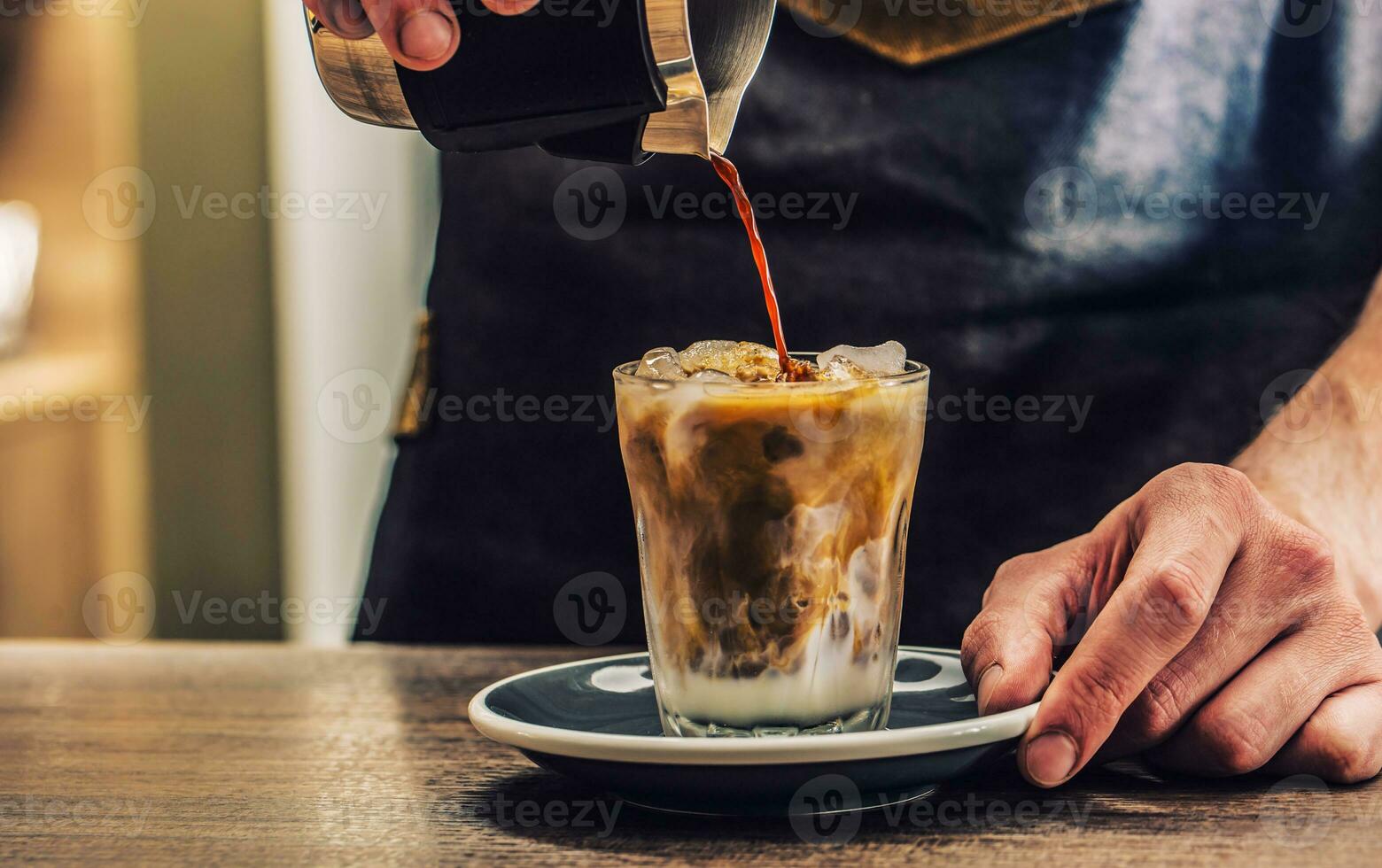 Nahansicht ein Barista Herstellung fres Eis Kaffee auf Bartheke foto