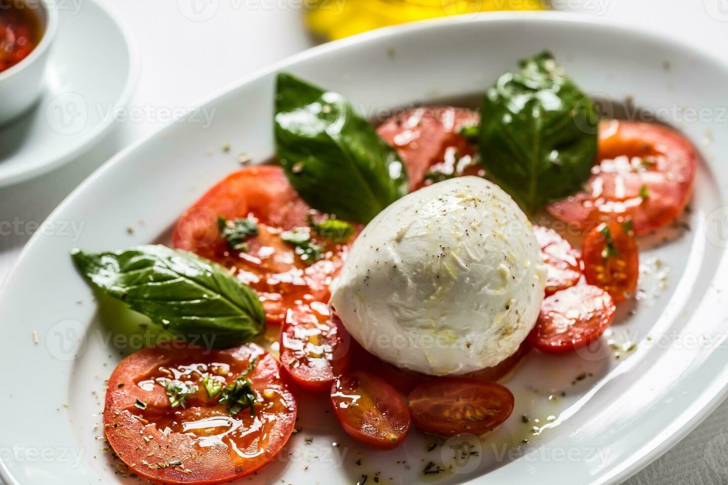 Caprese Salat von Mozzarella Tomaten Basilikum Olive Öl ein Gewürze foto