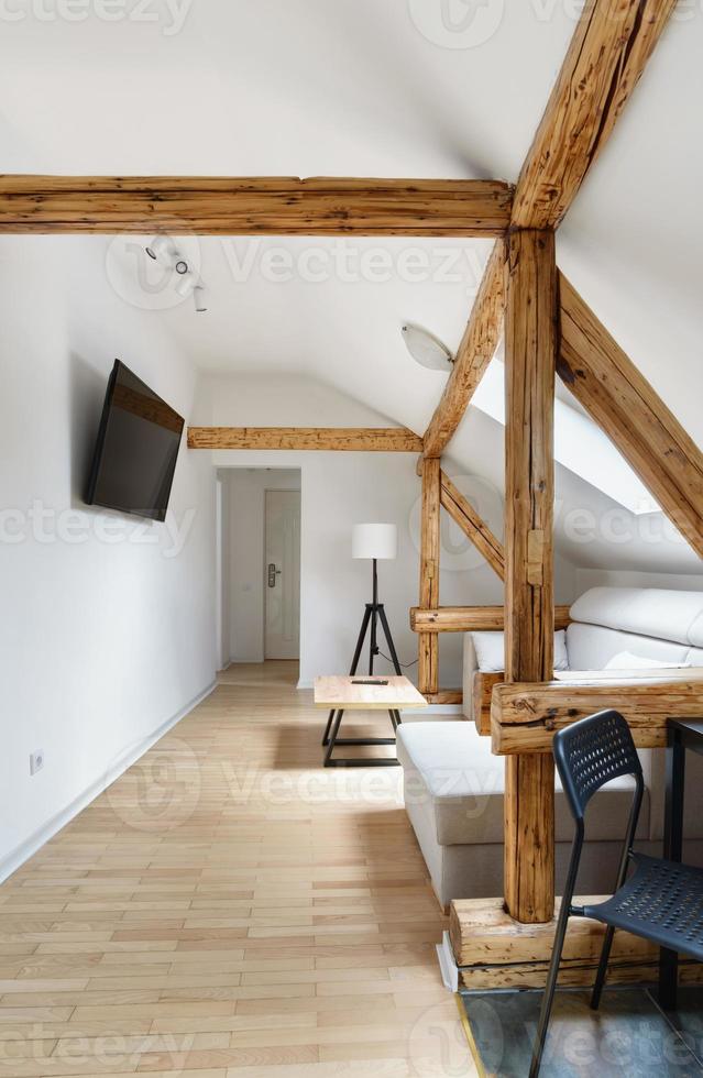 Dachgeschosswohnung, modernes Wohnzimmer, Innenarchitektur der Wohnung mit alten rustikalen Holzbalken, Böden und Möbeln. foto