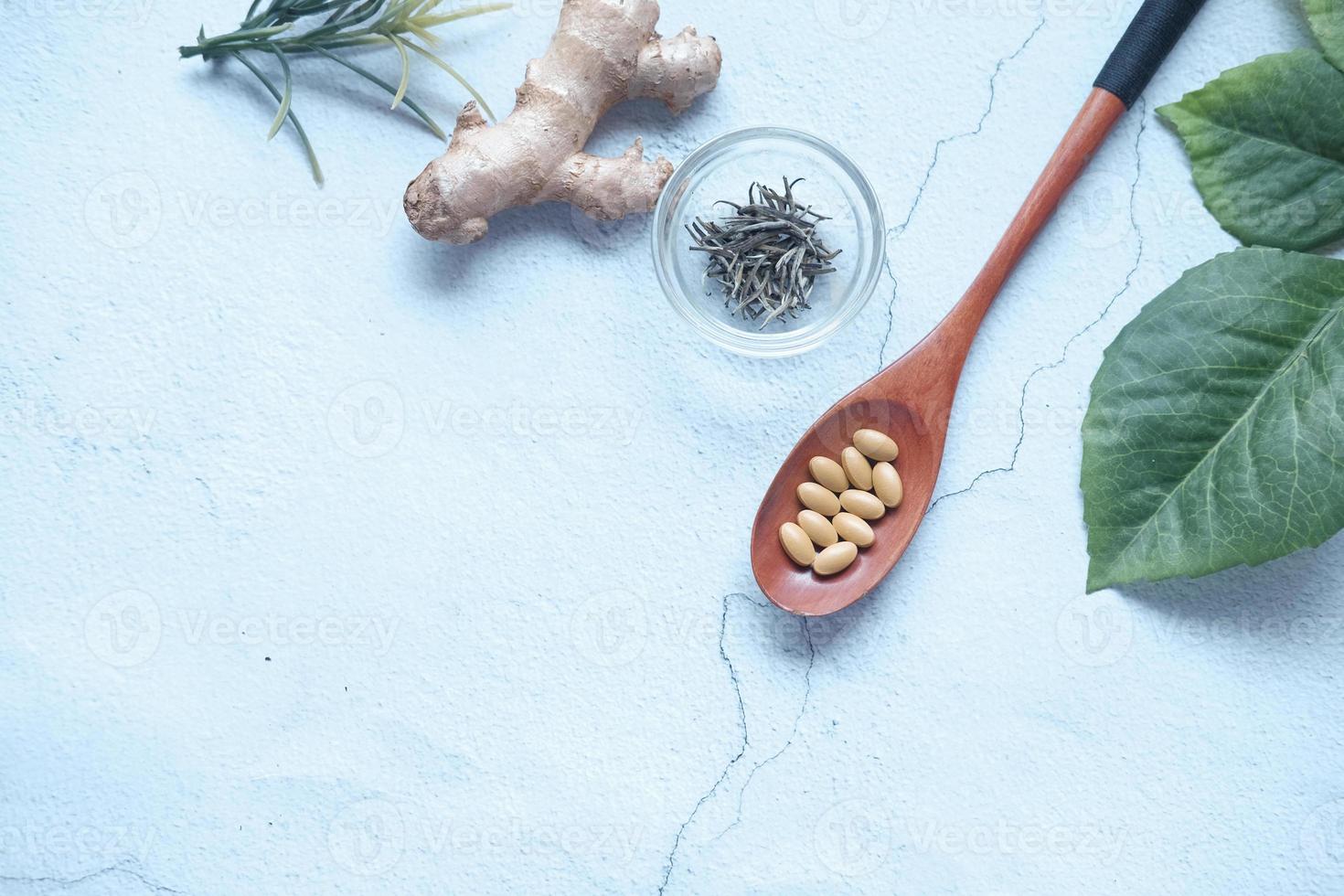 Kräutermedizin auf Löffel und Kräuter auf dem Tisch foto