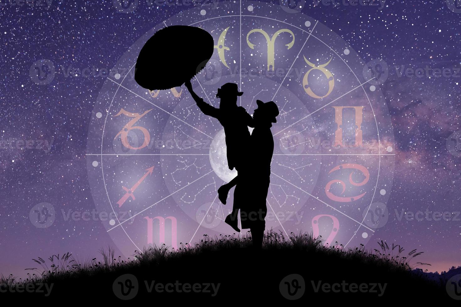 Paar singt und tanzt über das Tierkreisrad und den Hintergrund der Milchstraße foto