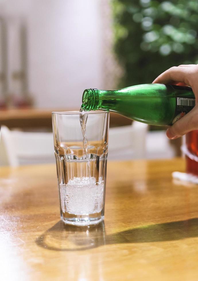 Mineralwasser ins Glas gießen foto