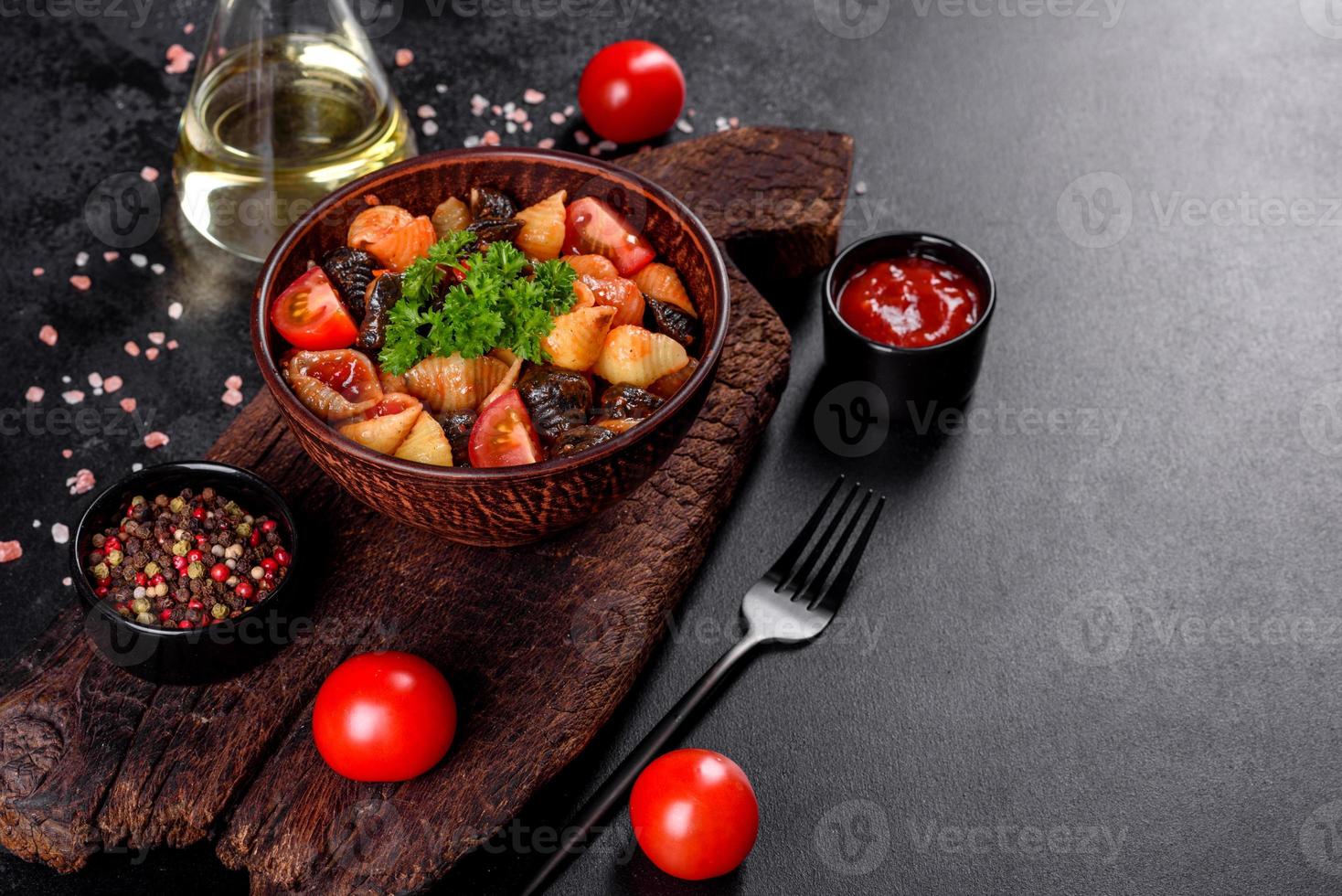 köstliche frische Paste mit Tomatensauce mit Gewürzen und Kräutern auf dunklem Hintergrund foto