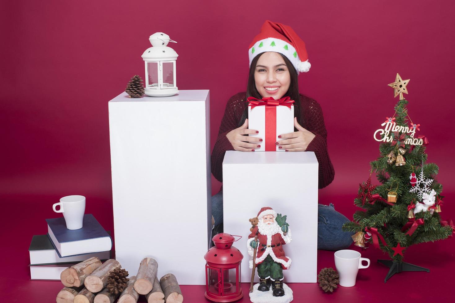 schönes Weihnachtsmann-Mädchen im Studio auf rotem Hintergrund, Weihnachtskonzept foto