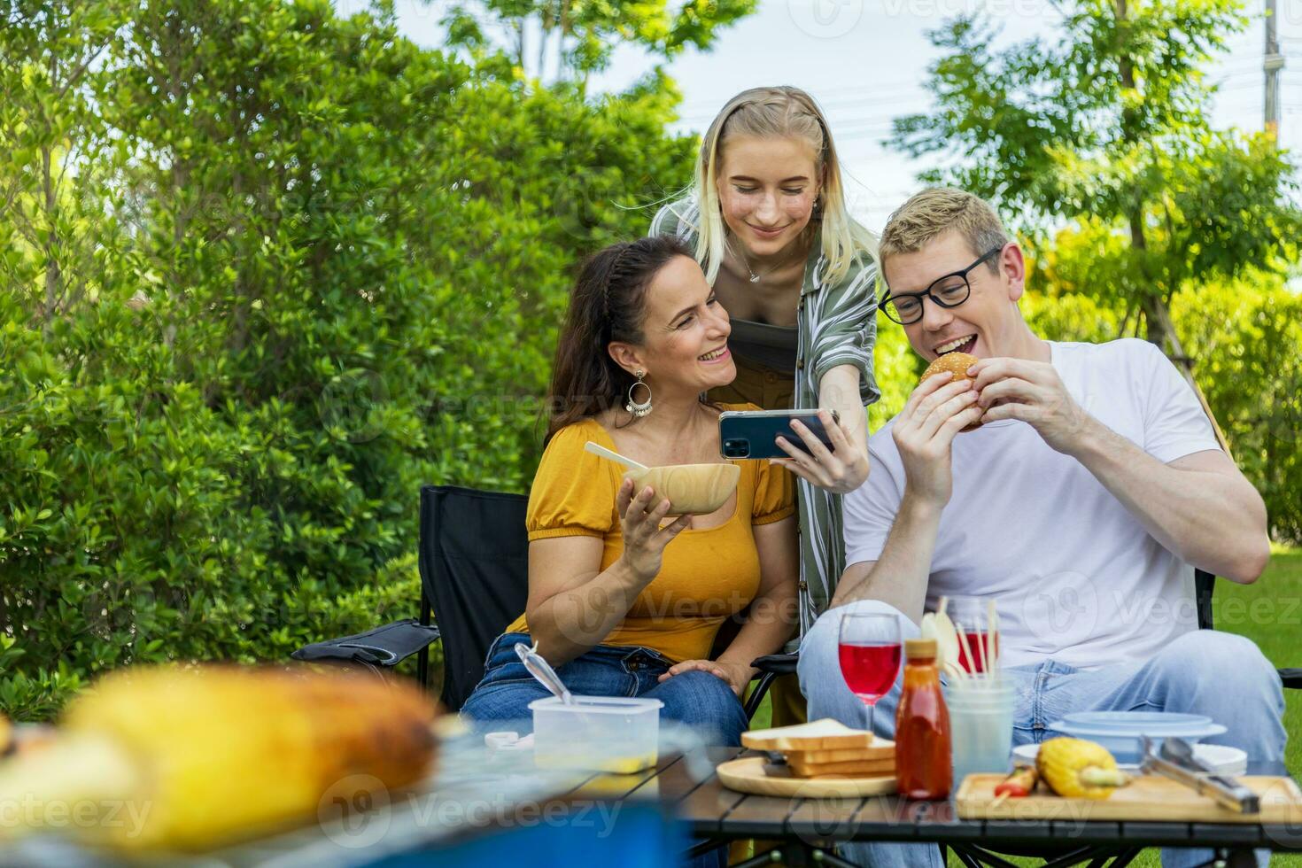Familie von Mutter und ihr Kinder nehmen Selfie beim Grill Picknick Ferien beim ihr Hinterhof während Sommer- während haben gut Essen und Zeit zusammen zum Liebe und Geschwister Konzept foto