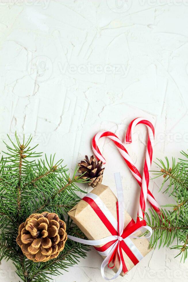 Weihnachten oder Neu Jahr Dekorationen Hintergrund mit Kiefer Zapfen, Tanne Geäst, Geschenk Kisten, und Süßigkeiten Stöcke foto