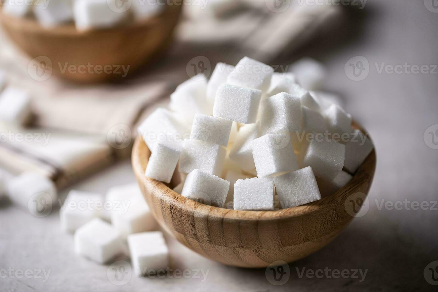 Weiß Zucker Würfel im ein hölzern Schüssel auf das Tabelle foto