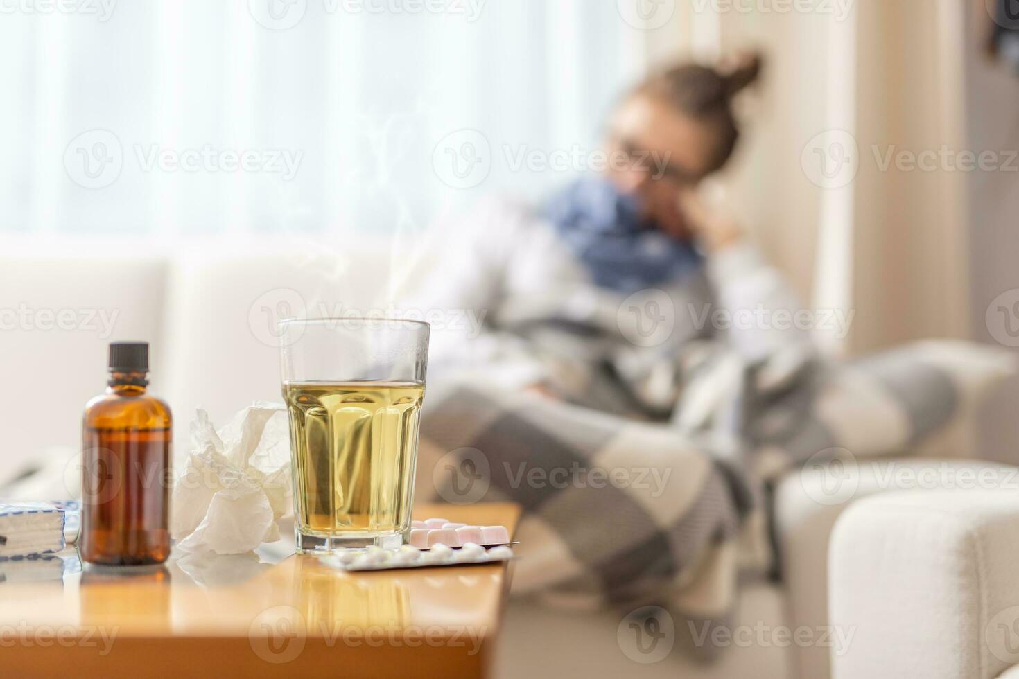 jung krank Frau Lügen unter Decke im ein Bett mit saisonal illnes Trinken heiß Tee mit Honig und Zitrone. sie nimmt Tabletten und Husten Sirup zu drücken das Krankheit foto