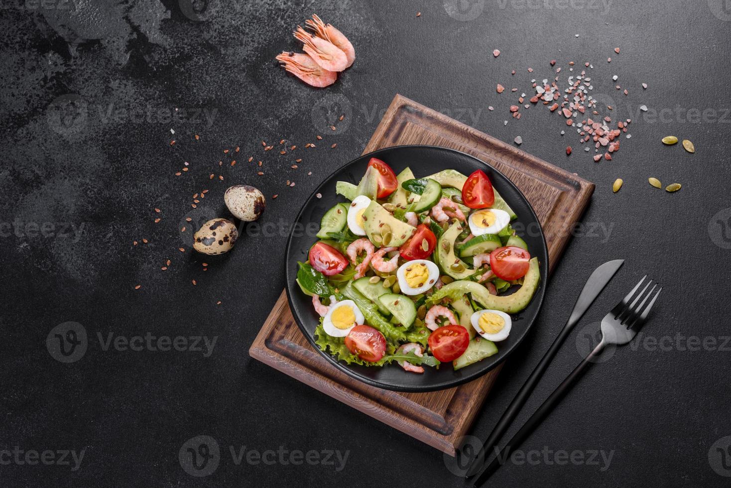 Salat mit Garnelen, Avocado, Gurke, Kürbiskernen und Leinsamen mit Olivenöl foto