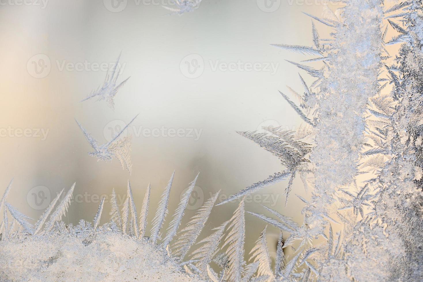Frostmuster auf dem Glas des Winterfensters bei klirrender Kälte foto