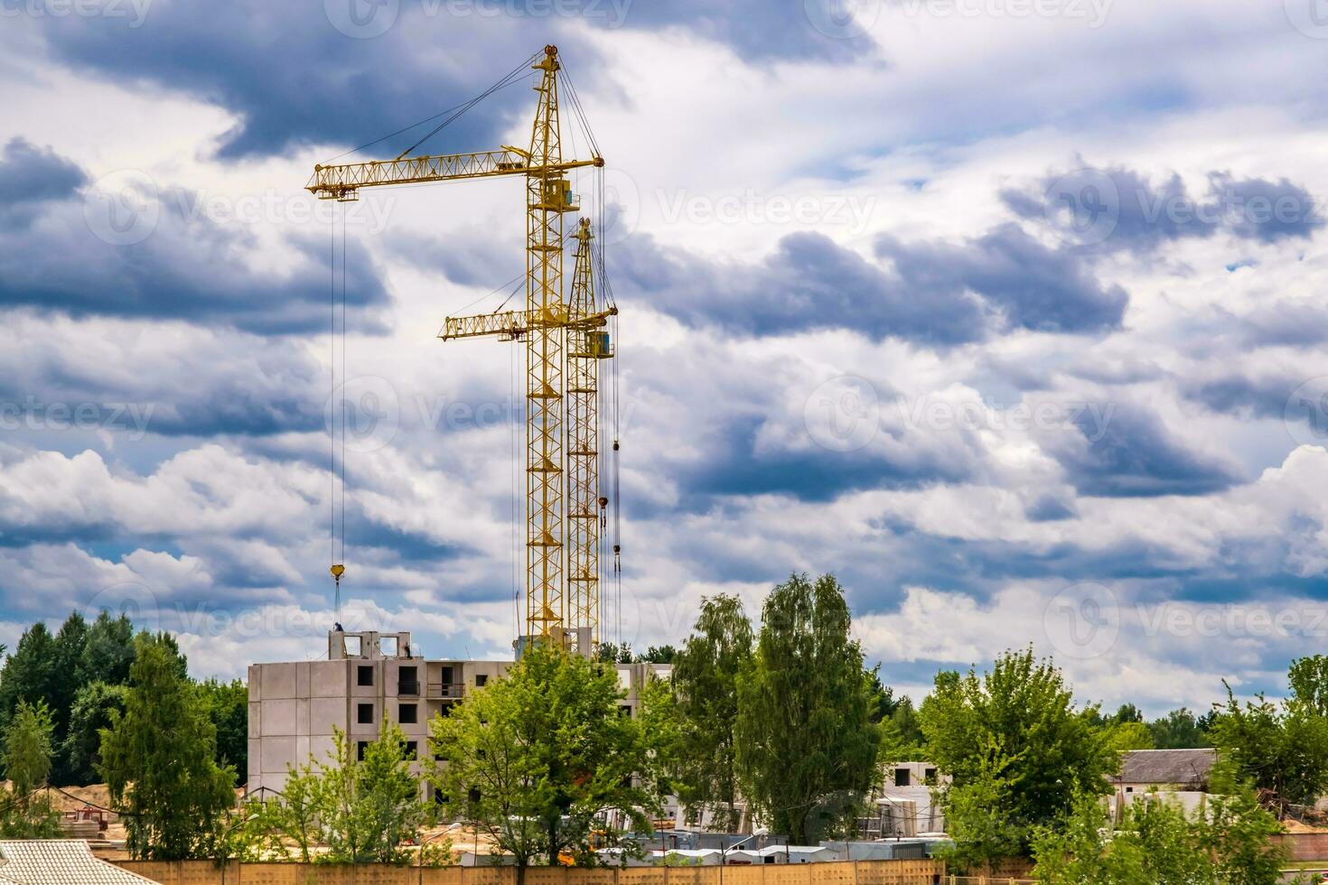 zwei Turm Kräne Arbeiten auf Konstruktion mit Sturm flauschige lockig rollen Wolken wie Hintergrund foto