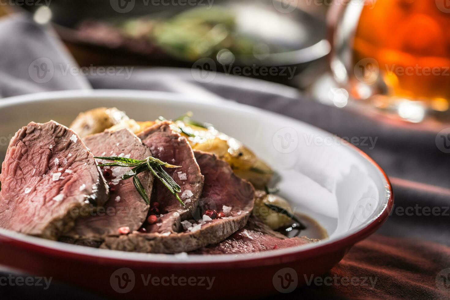 geschnitten Rindfleisch Filet geröstet Steak Kartoffeln Rosmarin und Entwurf Bier foto