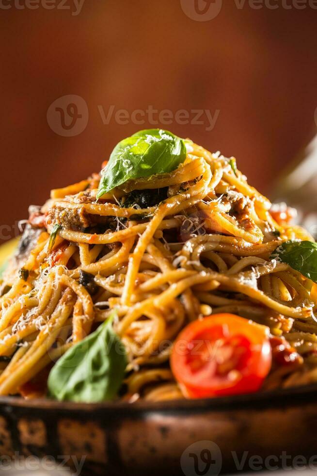 Italienisch Pasta Spaghetti mit Tomate Soße Olive Öl Basilikum und Parmesan Käse im alt schwenken foto