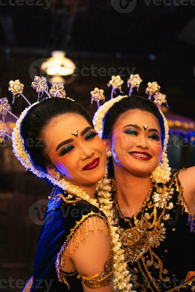 zwei javanisch Tänzer im Gelb Schals nehmen Bilder mit lächerlich Gesichter foto